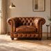 Poltrona Chesterfield in pelle cognac in un angolo lettura luminoso